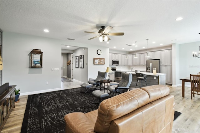 1272 Bonita Canyon Dr, Kissimmee, FL 34759 - living area featuring a ceiling fan, light wood-style flooring, baseboards, a chandelier, and recessed lighting