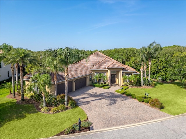 7 Spanish Moss Ct, Palm Coast, FL 32137 - mediterranean / spanish home with a garage, a tile roof, driveway, a front lawn, and stucco siding