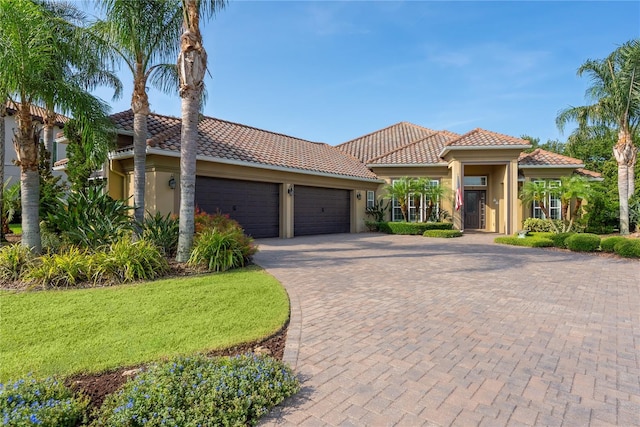7 Spanish Moss Ct, Palm Coast, FL 32137 - mediterranean / spanish home featuring stucco siding, a tile roof, a garage, decorative driveway, and a front yard