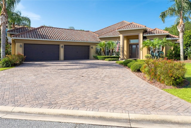 7 Spanish Moss Ct, Palm Coast, FL 32137 - mediterranean / spanish house with a tile roof, stucco siding, an attached garage, and decorative driveway