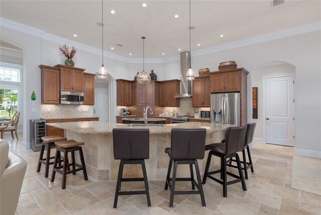 7 Spanish Moss Ct, Palm Coast, FL 32137 - kitchen featuring appliances with stainless steel finishes, wine cooler, arched walkways, a sink, and wall chimney range hood