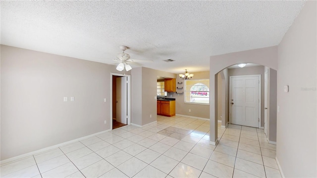 114 N Alderwood St, Winter Springs, FL 32708 - empty room with a chandelier, a ceiling fan, arched walkways, a textured ceiling, and light tile patterned floors