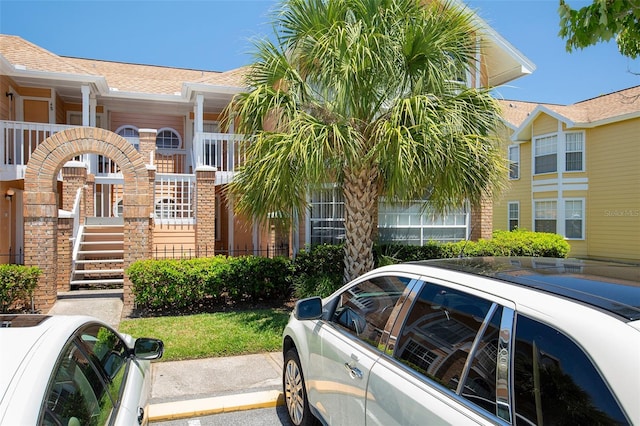 2438 Sweetwater Club Cir Unit 50, Kissimmee, FL 34746 - view of front facade featuring uncovered parking and a shingled roof