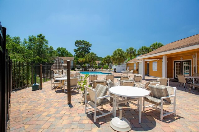 2438 Sweetwater Club Cir Unit 50, Kissimmee, FL 34746 - view of patio featuring a community pool, fence, and outdoor dining area