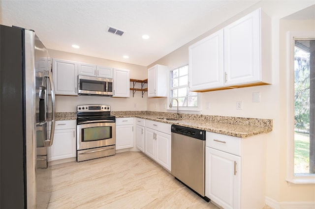 120 W Minnehaha Ave, Clermont, FL 34711 - kitchen with appliances with stainless steel finishes, a sink, white cabinets, light stone counters, and recessed lighting