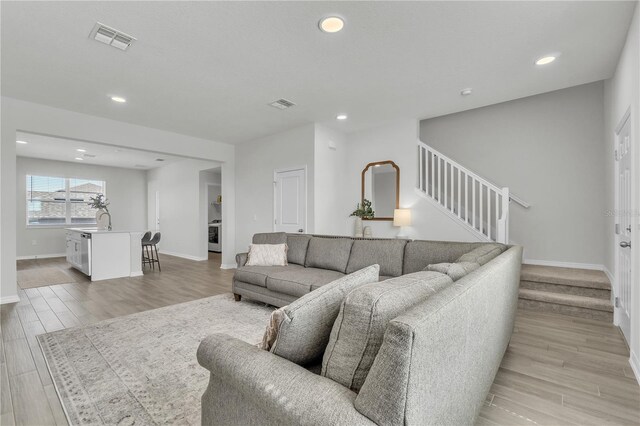 12190 Plumpton Dr, Winter Garden, FL 34787 - living room with baseboards, stairway, light wood finished floors, and recessed lighting