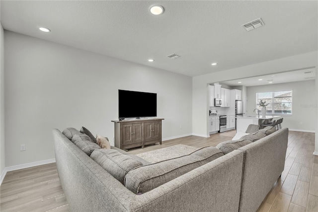 12190 Plumpton Dr, Winter Garden, FL 34787 - living area featuring baseboards, light wood-style floors, and recessed lighting