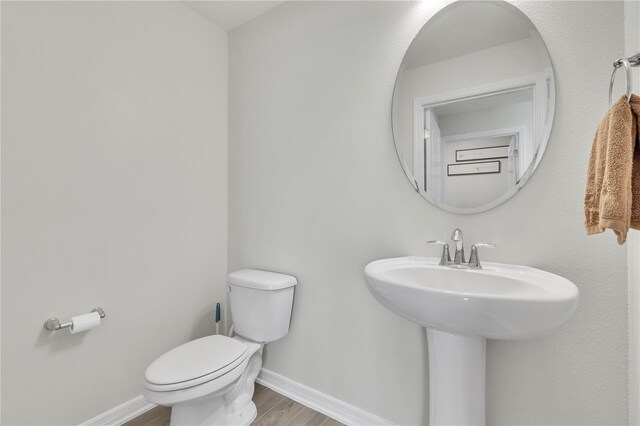 12190 Plumpton Dr, Winter Garden, FL 34787 - bathroom featuring toilet, wood finished floors, baseboards, and a sink