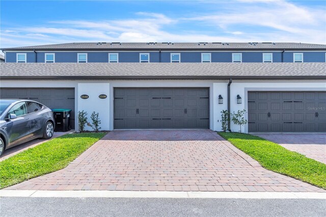 12190 Plumpton Dr, Winter Garden, FL 34787 - view of property featuring stucco siding and community garages