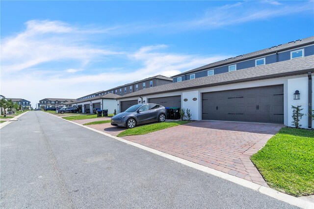 12190 Plumpton Dr, Winter Garden, FL 34787 - view of front of house with a residential view, stucco siding, and decorative driveway