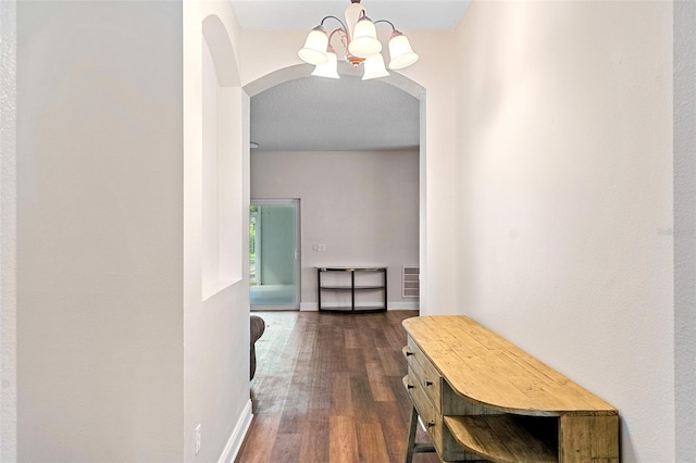 7013 Beargrass Rd, Harmony, FL 34773 - hall with a chandelier, arched walkways, and dark wood-type flooring