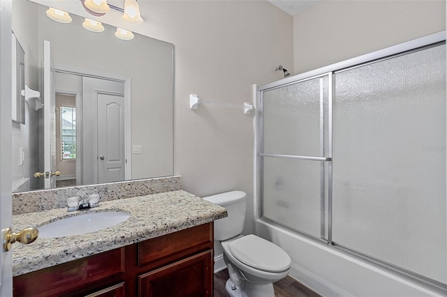 7013 Beargrass Rd, Harmony, FL 34773 - full bathroom with vanity, bath / shower combo with glass door, and wood finished floors