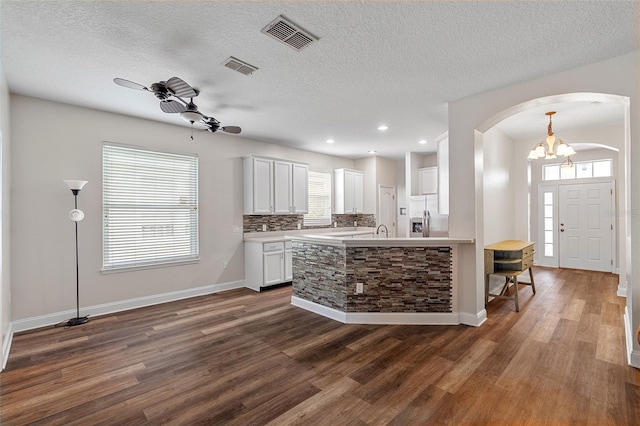 7013 Beargrass Rd, Harmony, FL 34773 - kitchen featuring dark wood finished floors, arched walkways, light countertops, a textured ceiling, and recessed lighting