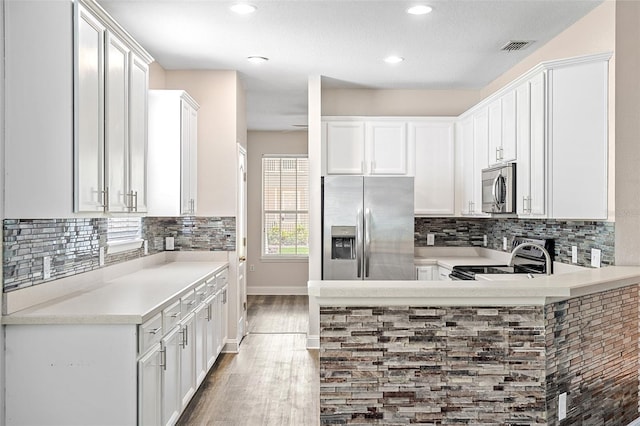 7013 Beargrass Rd, Harmony, FL 34773 - kitchen featuring appliances with stainless steel finishes, wood finished floors, light countertops, decorative backsplash, and recessed lighting