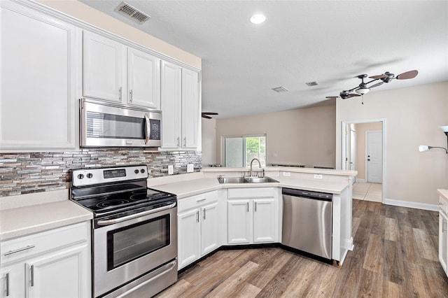 7013 Beargrass Rd, Harmony, FL 34773 - kitchen with stainless steel appliances, a ceiling fan, backsplash, and a peninsula