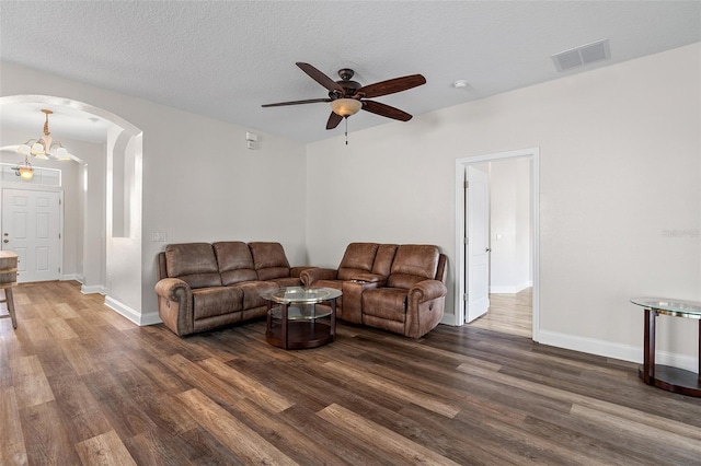 7013 Beargrass Rd, Harmony, FL 34773 - living area featuring arched walkways, dark wood-style flooring, ceiling fan, and a textured ceiling
