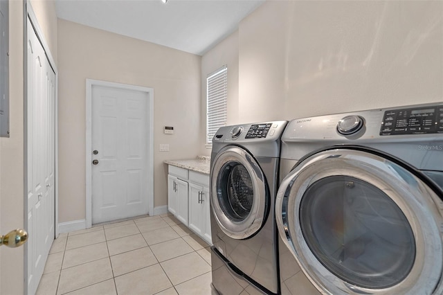 7013 Beargrass Rd, Harmony, FL 34773 - washroom featuring separate washer and dryer, cabinet space, and light tile patterned floors