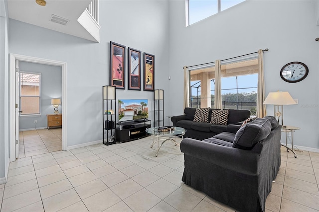 321 Rosso Dr, Davenport, FL 33837 - living area with a towering ceiling, baseboards, light tile patterned floors, and plenty of natural light