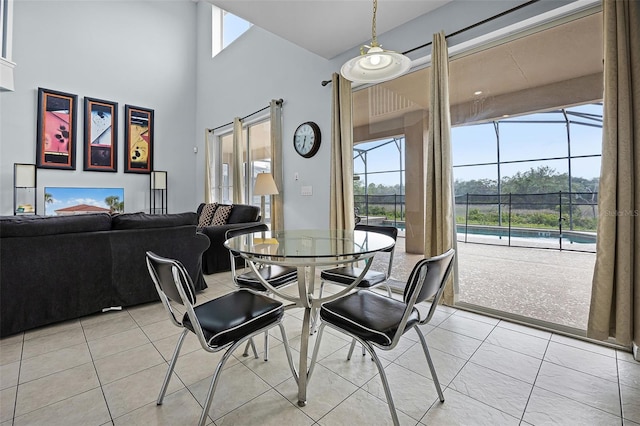 321 Rosso Dr, Davenport, FL 33837 - dining area featuring healthy amount of natural light, light tile patterned flooring, a towering ceiling, and a sunroom