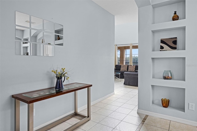 321 Rosso Dr, Davenport, FL 33837 - hall featuring light tile patterned flooring, a towering ceiling, and baseboards