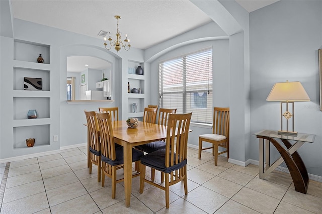 321 Rosso Dr, Davenport, FL 33837 - dining room with built in shelves, arched walkways, baseboards, and light tile patterned floors