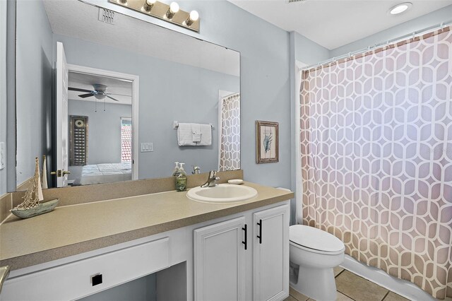 321 Rosso Dr, Davenport, FL 33837 - ensuite bathroom featuring toilet, tile patterned floors, vanity, ceiling fan, and a shower with curtain