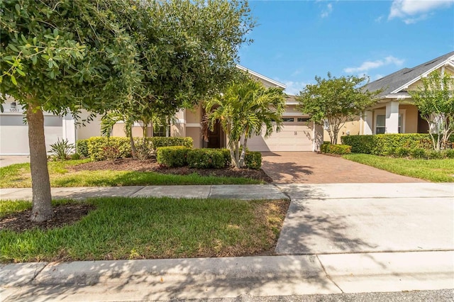 5009 E Fountainwood Dr, Saint Cloud, FL 34772 - obstructed view of property with a garage, decorative driveway, and stucco siding