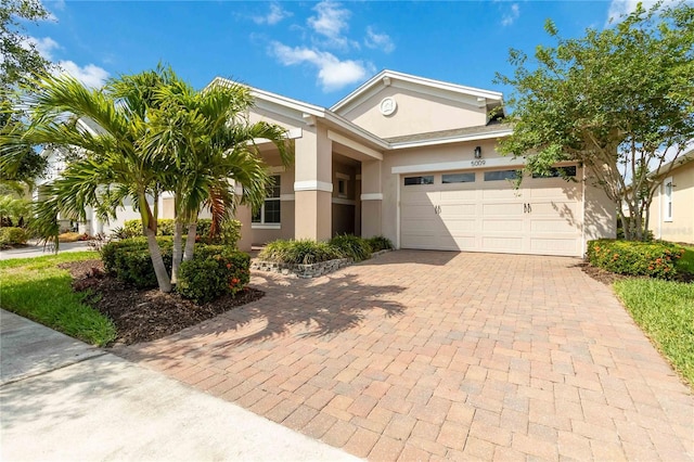 5009 E Fountainwood Dr, Saint Cloud, FL 34772 - view of front of house with decorative driveway, a garage, and stucco siding