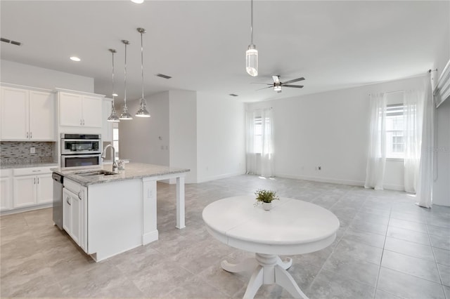 5009 E Fountainwood Dr, Saint Cloud, FL 34772 - kitchen featuring a sink, stainless steel appliances, tasteful backsplash, ceiling fan, and white cabinetry