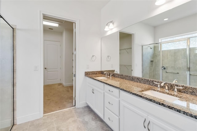 5009 E Fountainwood Dr, Saint Cloud, FL 34772 - bathroom featuring a shower stall, double vanity, a walk in closet, baseboards, and tile patterned flooring