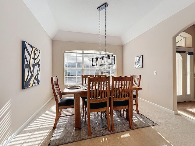 518 Brighton Dr, Davenport, FL 33897 - dining space with light colored carpet, arched walkways, baseboards, and lofted ceiling