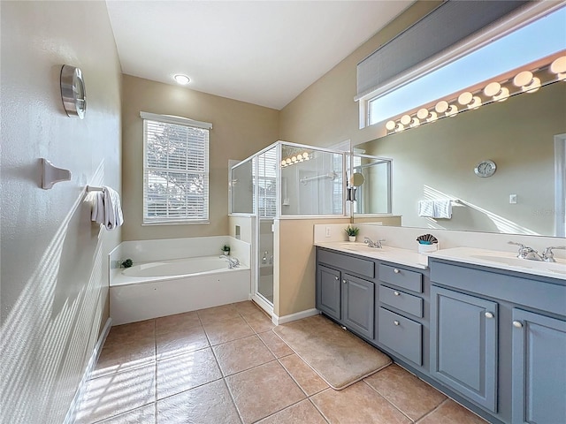 518 Brighton Dr, Davenport, FL 33897 - bathroom featuring tile patterned floors, double vanity, a shower stall, a bath, and baseboards