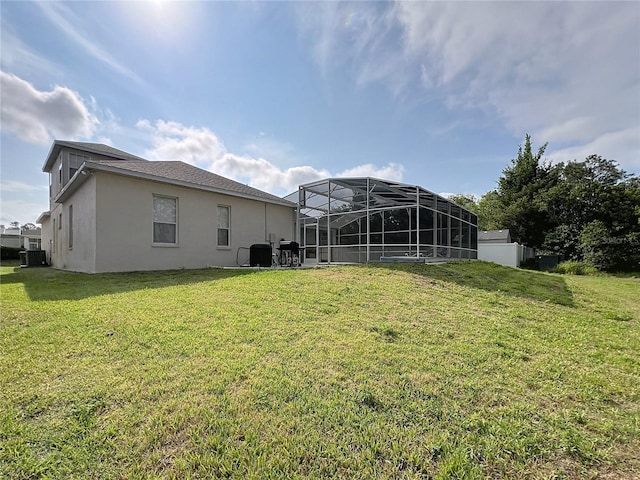 518 Brighton Dr, Davenport, FL 33897 - rear view of house featuring stucco siding, a yard, a lanai, and central AC