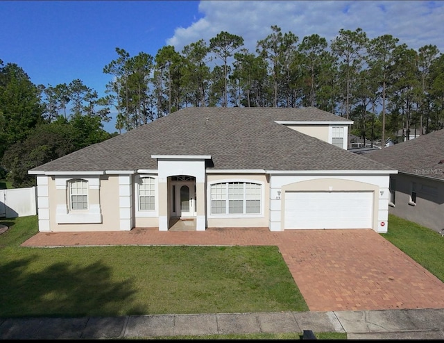 518 Brighton Dr, Davenport, FL 33897 - view of front of property with roof with shingles, stucco siding, an attached garage, and decorative driveway