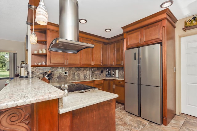 955 Mansfield Rd, Tavares, FL 32778 - kitchen with freestanding refrigerator, island exhaust hood, a peninsula, stovetop, and brown cabinetry