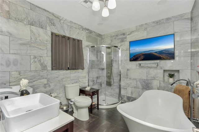955 Mansfield Rd, Tavares, FL 32778 - full bathroom with tile walls, a shower stall, a soaking tub, toilet, and vanity