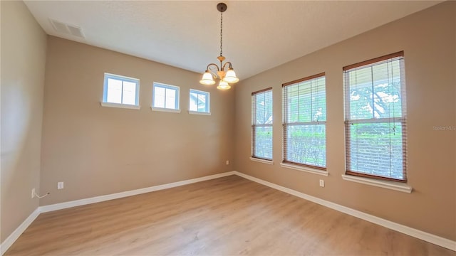 6957 Northwich Dr, Windermere, FL 34786 - unfurnished room featuring light wood-type flooring, baseboards, and a chandelier