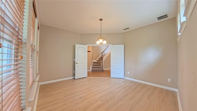 6957 Northwich Dr, Windermere, FL 34786 - spare room with light wood finished floors, baseboards, and a chandelier