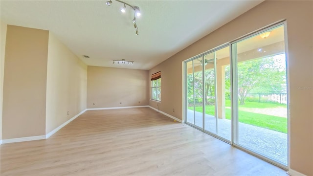 6957 Northwich Dr, Windermere, FL 34786 - unfurnished room with rail lighting, light wood-style floors, and baseboards