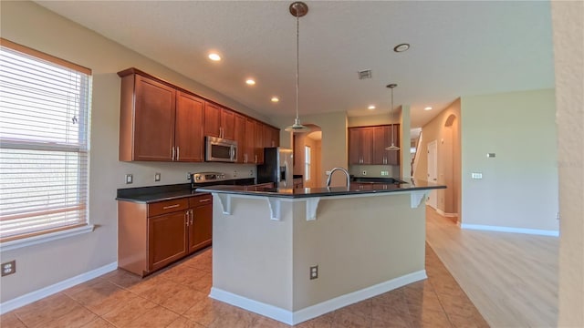 6957 Northwich Dr, Windermere, FL 34786 - kitchen with stainless steel appliances, arched walkways, plenty of natural light, dark countertops, and recessed lighting