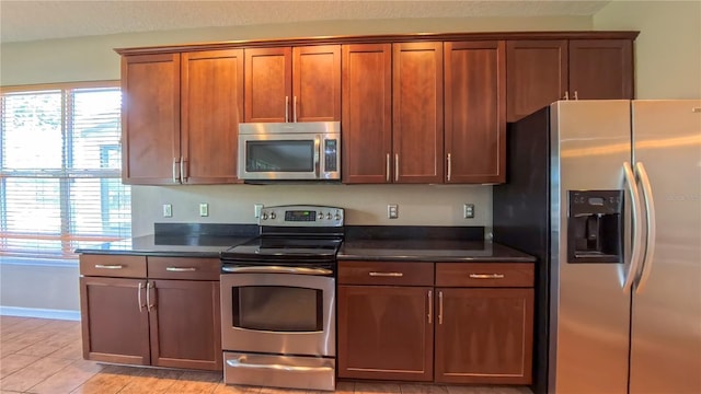 6957 Northwich Dr, Windermere, FL 34786 - kitchen with stainless steel appliances, dark countertops, brown cabinets, and baseboards