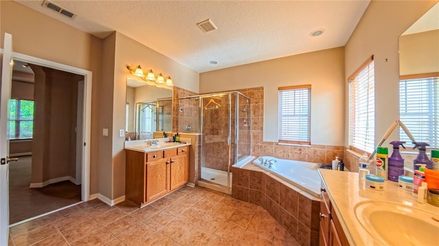 6957 Northwich Dr, Windermere, FL 34786 - bathroom with plenty of natural light, two vanities, a garden tub, and a textured ceiling