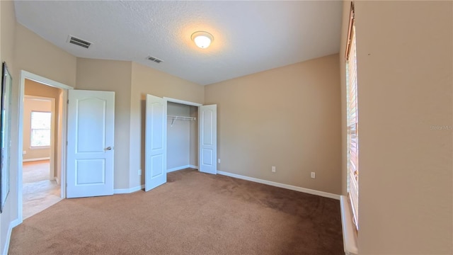 6957 Northwich Dr, Windermere, FL 34786 - unfurnished bedroom with carpet, baseboards, a closet, and a textured ceiling