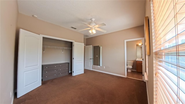 6957 Northwich Dr, Windermere, FL 34786 - unfurnished bedroom featuring dark carpet, a closet, baseboards, connected bathroom, and a ceiling fan