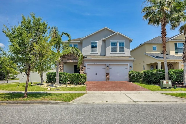 3400 Mt Vernon Way, Kissimmee, FL 34741 - view of front of home featuring decorative driveway, stucco siding, a garage, and stone siding