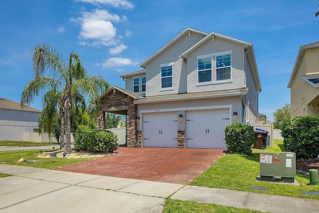 3400 Mt Vernon Way, Kissimmee, FL 34741 - view of front of house with decorative driveway, a garage, a front lawn, stucco siding, and stone siding