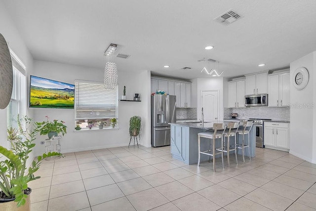 3400 Mt Vernon Way, Kissimmee, FL 34741 - kitchen with stainless steel appliances, decorative backsplash, a breakfast bar area, light tile patterned flooring, and recessed lighting