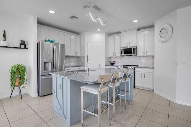 3400 Mt Vernon Way, Kissimmee, FL 34741 - kitchen featuring appliances with stainless steel finishes, a sink, light tile patterned floors, decorative backsplash, and recessed lighting