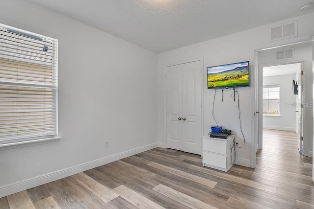 3400 Mt Vernon Way, Kissimmee, FL 34741 - unfurnished bedroom featuring wood finished floors, baseboards, a closet, and a textured ceiling
