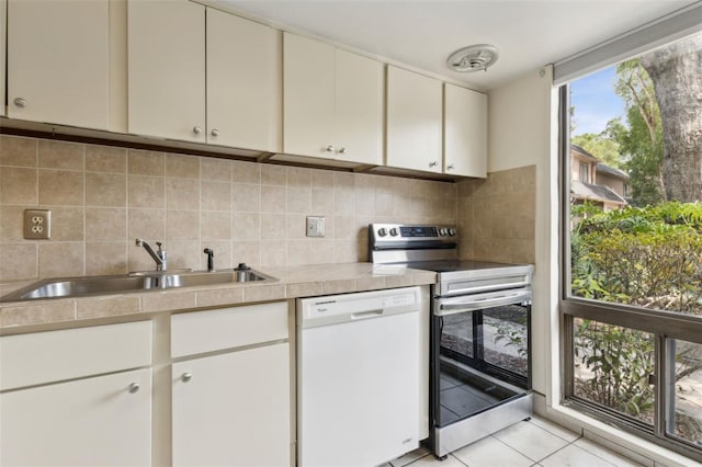 411 Sheoah Blvd Unit 33, Winter Springs, FL 32708 - kitchen with dishwasher, stainless steel range with electric stovetop, a sink, light tile patterned floors, and backsplash